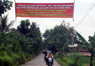 Spanduk bertuliskan protes warga terhadap kondisi jalan yang selama ini rusak dan membuat warga tidak nyaman. Foto : Andri S Hamara/HR.