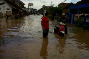 Seorang pengendara sepeda motor, di jalur utama Panumbangan, nekad melintas di genangan banjir. Tak sedikit sepeda motor yang nekad melintas di jalan banjir yang mengalami mogok, Kamis (25/7). Foto: Eli Suherli/HR