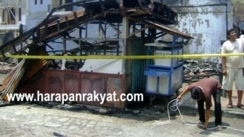 Salah seorang pedagang tengah membersihkan puing-puing sisa kebakaran yang menghanguskan 14 kios pedagang eks Bioskop Kenangan, Kamis (12/9). Foto: Deni Supendi/HR