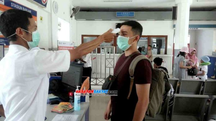 Calon penumpang kereta api di Stasiun KA Kota Banjar saat dilakukan pemeriksaan suhu badan oleh petugas.