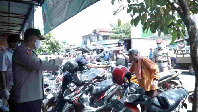 Tim operasi gabungan saat memberikan masker kepada warga. Foto: Istimewa.