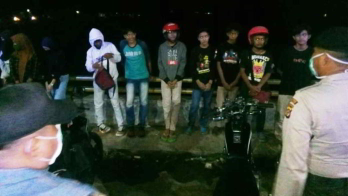 Sekelompok remaja yang sedang asyik berkumpul di Jembatan Dobo pun dibubarkan paksa oleh tim petugas kepolisian, Sabtu (11/04/2020) malam. Foto: Istimewa.