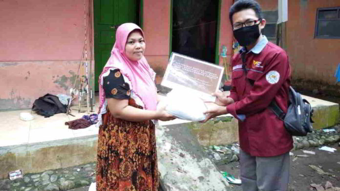 Salah seorang pengurus Yayasan Al-Kautsar saat memberikan santunan kepada warga. Foto: Istimewa.
