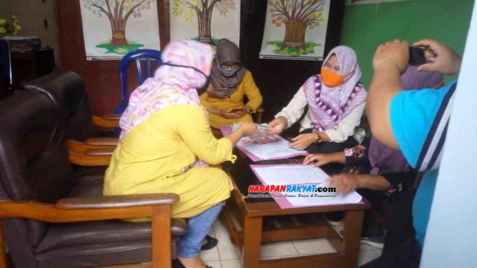 Salah satu orang tua peserta didik saat menerima uang yang dikembalikan oleh pihak sekolah. Foto: Muhlisin/HR.