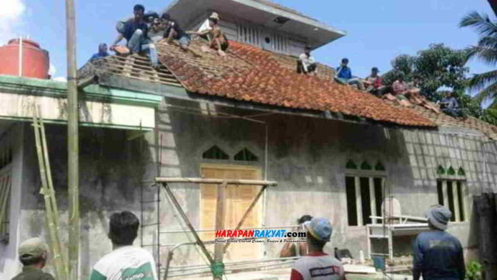 Warga Cigantang Hilir, Kelurahan Cigantang, Kecamatan Mangkubumi, Kota Tasikmalaya, menjaga imun tubuh sambil bergotong-royong membongkar Masjid Jami Al-Hikmah. Foto: Apip Wilianto/HR.