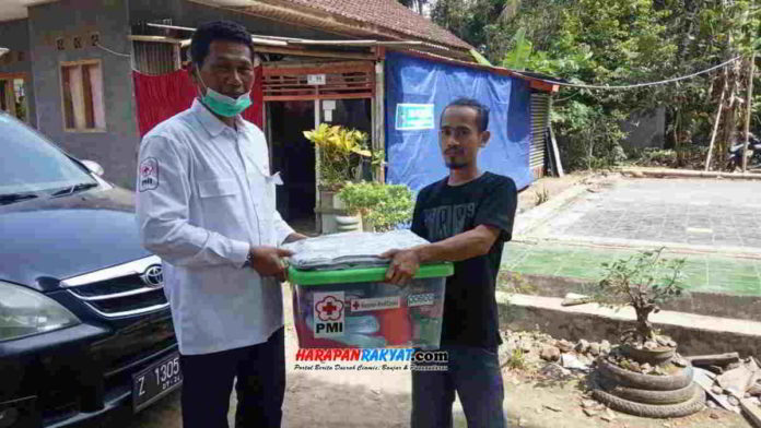 Keluarga Hudri (34), korban rumah kebakaran di Dusun Sidamulya, RT. 02/01, Desa Sukamukti, Kecamatan Pamarican, Kabupaten Ciamis, menerima bantuan dari PMI Kabupaten Ciamis. Foto: Suherman/HR.