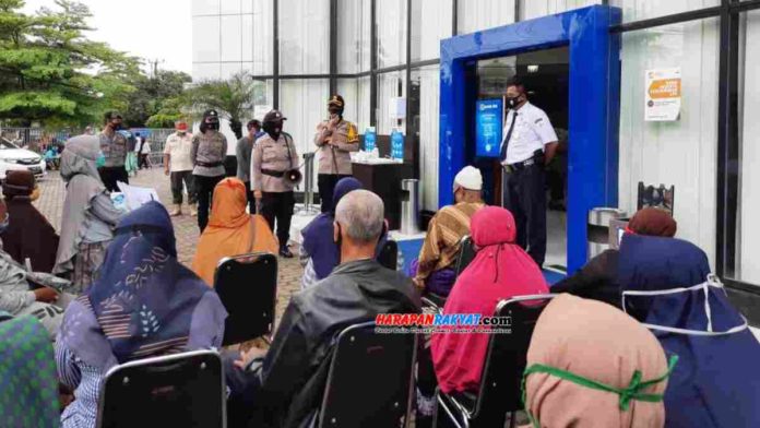 Kapolres Banjar ingatkan 3M dan 1T kepada warga yang tengah mengantri di Kantor BRI Cabang Kota Banjar, Jawa Barat, Jum’at (23/10/2020). Foto: Aji Saomara/HR.