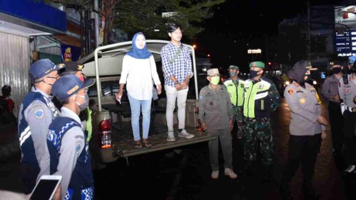 Sepasang muda-mudi saat dihukum Tim Satgas Penindakan Protokol Kesehatan Kota Banjar. Foto: Istimewa.