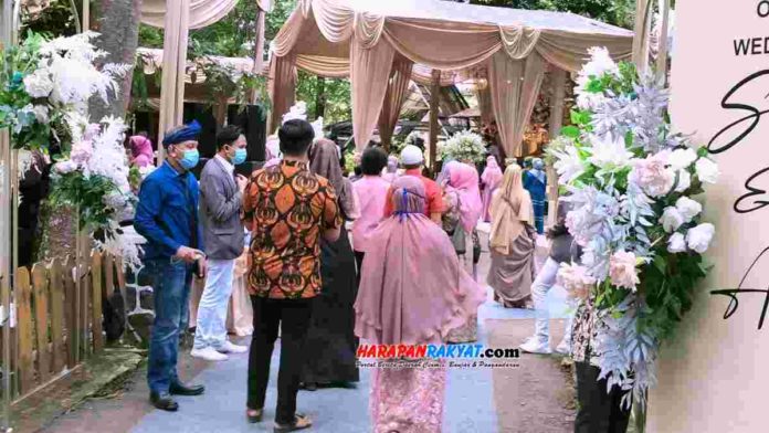 Kasus Covid-19 Banjar Meningkat, Warga Gelar Hajatan Tak Ditindak Tim Satgas Berita Banjar (harapanrakyat.com),- Kasus Covid-19 Kota Banjar, Jawa Barat, terus meningkat. Namun, di tengah meningkatnya kasus positif dan warga yang meninggal dunia karena terpapar virus Corona, ada warga yang malah menggelar hajatan di tempat wisata Situ Mustika. Tak pelak, acara resepsi pernikahan pada Minggu (20/12/2020), yang dihadiri banyak tamu undangan itu menimbulkan kerumunan. Dikonfirmasi adanya kerumunan dan perizinan pada acara resepsi pernikahan tersebut, Kepala Dinas Pemuda, Olahraga dan Pariwisata Kota Banjar, Dedi Suardi, yang juga anggota Tim Satgas Percepatan Penanganan Covid-19, mengatakan, acara tersebut belum mendapatkan izin. Menurutnya, belum adanya izin tersebut karena sampai hari Jum”at (18/12/2020), Tim Satgas belum menerima izin dari pihak yang menyelenggarakan acara tersebut. “Menurut data di Posko Satgas, pada hari Jum’at,tidak ada data dari pihak penyelenggara yang akan melaksanakan hajatan (tidak minta izin) pada tempat wisata itu,” singkat Dedi Suardi, kepada HR Online. Namun demikian, pantauan di lokasi, nampak Kapolsek Purwaharja, IPTU. M Taufik Maulidiana, dan Camat Purwaharja, memantau acara hajatan tersebut. IPTU. M Taufik Maulidiana, mengatakan, pihaknya hanya melakukan pemantauan dan imbuan agar pelaksanakan acara resepsi pernikahan memperhatikan protokol kesehatan. Seperti menjaga jarak, menghindari kerumunan, dan memakai masker. Sedangkan, perihal penindakan tegas sampai pada pembubaran, hal itu perlu ada koordinasi dengan Tim Satgas Kota Banjar. “Kami hanya memantau dan memberikan imbauan agar betul-betul menjalankan protokol kesehatan sampai acara selesai,” kata Kapolsek Purwaharja, IPTU. M Taufik. Sebelumnya Tim Satgas Panggil Penyelenggara Hajatan Pada pemberitaan sebelumnya, pada tanggal 27 September 2020, Tim Satgas Kota Banjar memanggil salah seorang warga yang melangsungkan acara pernikahan di Desa Balokang, Kecamatan Banjar. Pada kesempatan tersebut, Ketua Pelaksana Satgas Kota Banjar, Ade Setiana, menegaskan bahwa saat ini tren kasus positif Covid-19 jumlahnya terus meningkat. Acara hajatan seperti resepsi pernikahan hanya mendapat izinkan untuk akad nikahnya saja. Selebihnya, rangkaian acara hiburan dan sebagainya yang bersifat mengundang kerumunan atau banyak orang, sampai saat ini Satgas Covid-19 belum memberikan izin. Apalagi yang tidak berizin pasti akan ditindak. (Muhlisin/R3/HR-Online) Editor : Eva Latifah Acara pernikahan di tempat wisata yang berlangsung tanpa izin tim Satgas Kota Banjar. Foto: Muhlisin/HR.