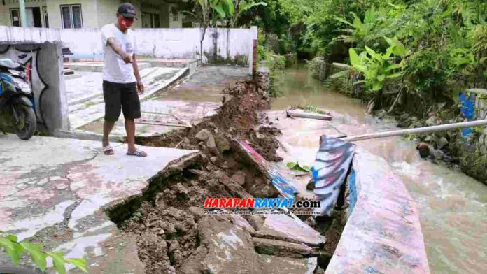Salah seorang warga saat menunjukan dinding Sungai Ciroas yang ambruk karena terkikis arus air. Menurut Dinas PUPRKP Kota Banjar, pembangunan saluran irigasi seperti normalisasi sungai terkendala anggaran. Foto: Muhlisin/HR.