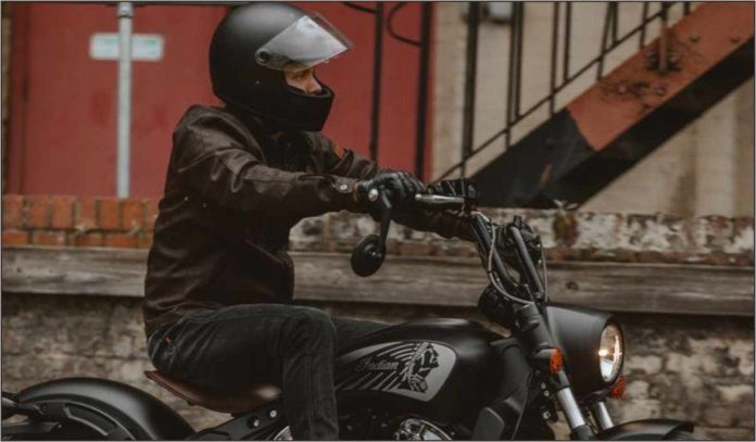 Seorang Pria Menunggangi Motor Sambil Mengenakan Helm