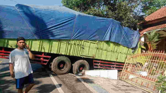Diduga Rem Blong, Tronton Bermuatan Kayu Jati Seruduk Pagar Rumah Warga di Pamarican Ciamis