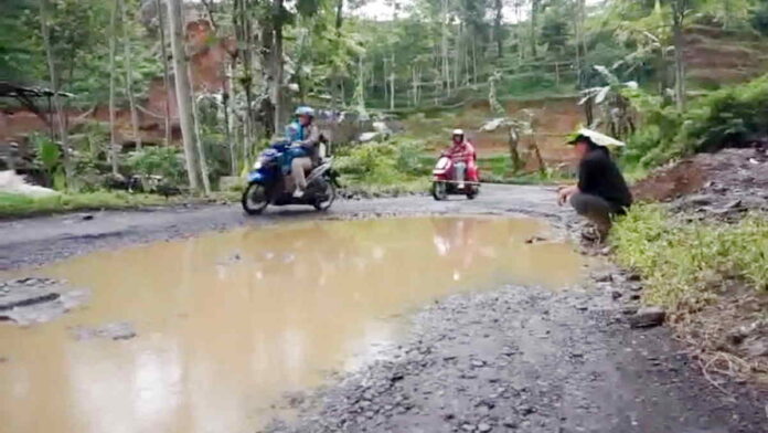 Aksi Pria Mancing Ikan di Jalan yang Rusak di Garut