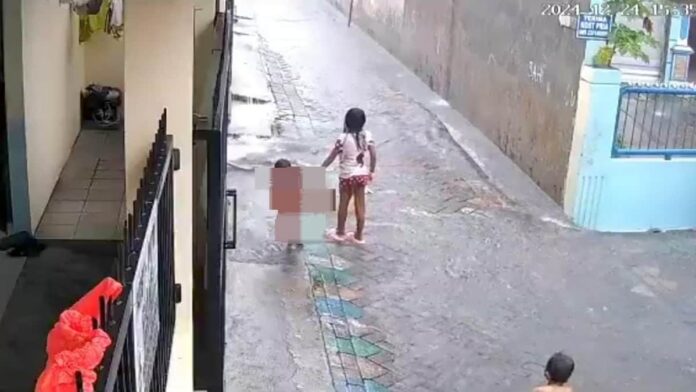 Balita terseret arus selokan saat bermain hujan di Surabaya terekam kamera CCTV dan viral di media sosial.