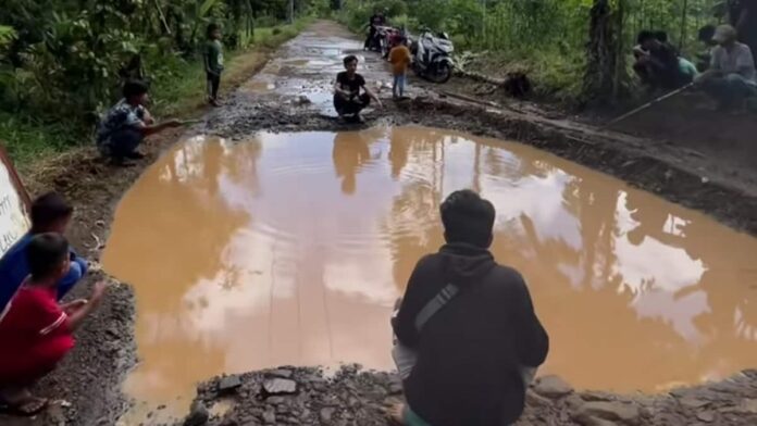 Warga Panumbangan Ciamis memancing di jalan rusak